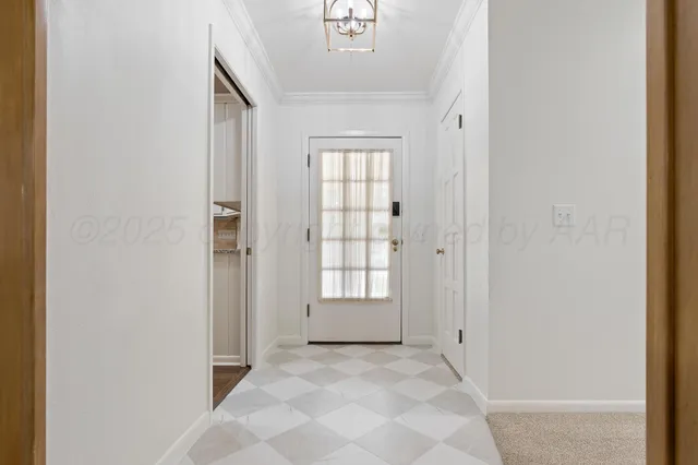 an empty room with windows and chandelier fan