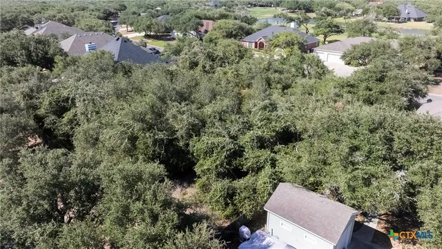 an aerial view of residential house with outdoor space and trees all around