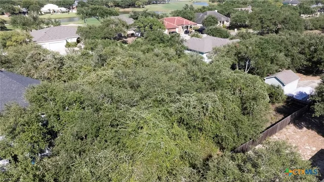 an aerial view of residential house with outdoor space and trees all around