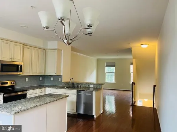 a kitchen with stainless steel appliances a sink a stove a refrigerator cabinets and a counter space