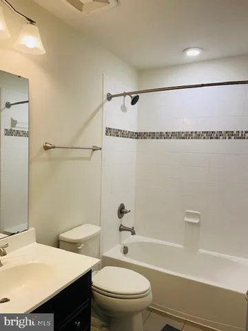 a bathroom with a granite countertop toilet a sink and a mirror