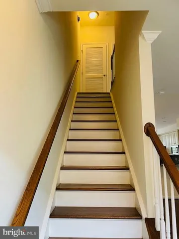 a view of a room with wooden floor and a kitchen