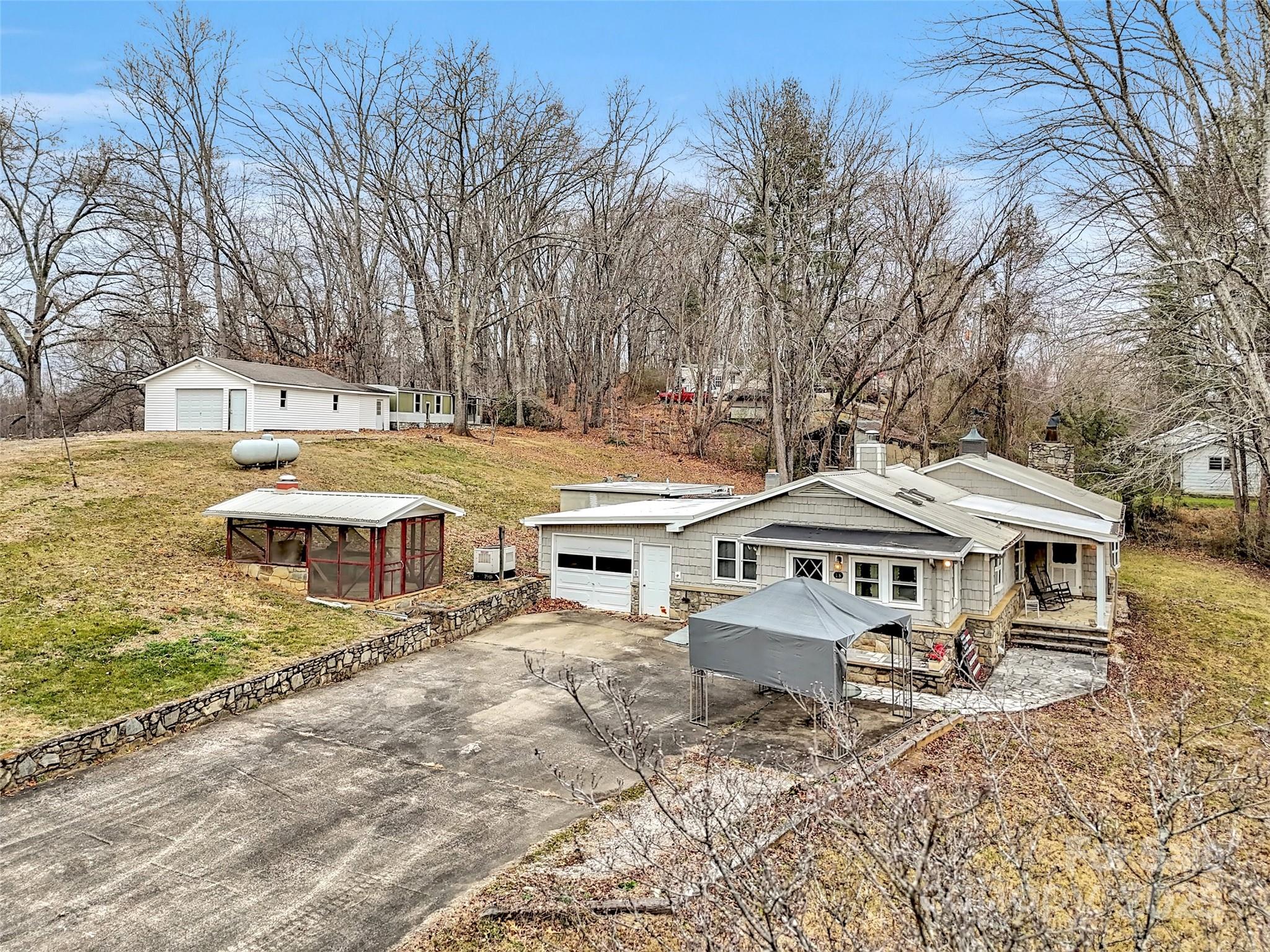 18 Sierra Point Waynesville, NC 28786 - Photo 29 of 48 a view of a white house with a large tree and lawn chairs