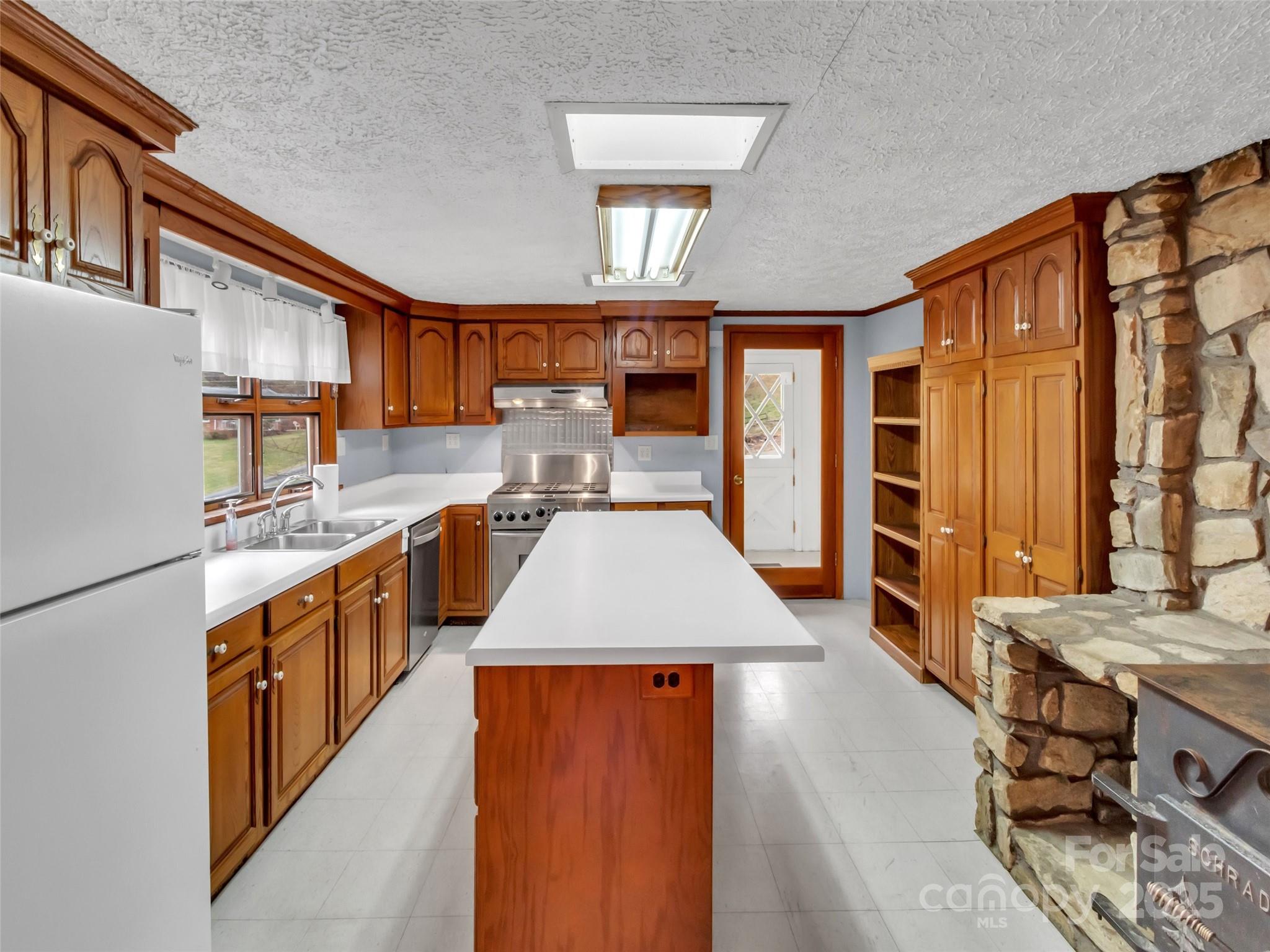 18 Sierra Point Waynesville, NC 28786 - Photo 8 of 48 a kitchen with stainless steel appliances granite countertop a sink a stove and wooden floors