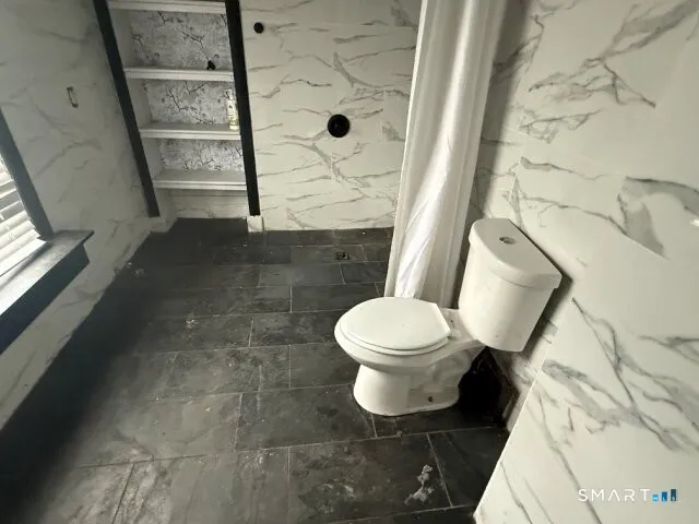 a bathroom with a toilet and a shower