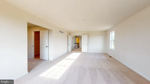 a view of empty room with wooden floor and window
