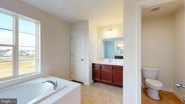 a bathroom with a bathtub toilet sink and mirror