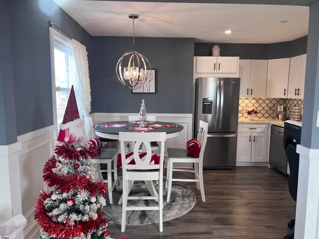 a living room with furniture a flat screen tv and kitchen view