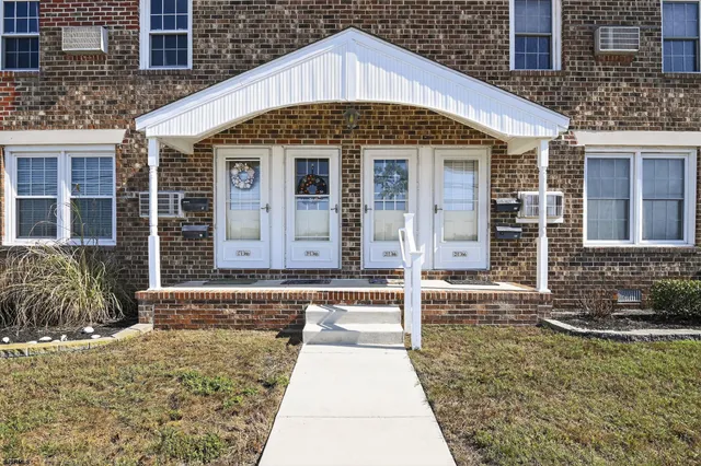 a front view of residential houses with street and trees