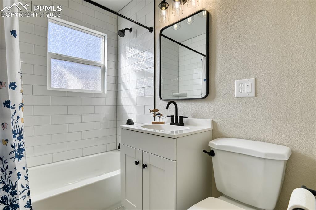 1422 Alexander Road Colorado Springs, CO 80909 - Photo 31 of 41 a bathroom with a toilet sink and mirror