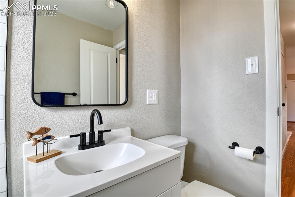 1422 Alexander Road Colorado Springs, CO 80909 - Photo 32 of 41 a bathroom with a granite countertop sink and a mirror