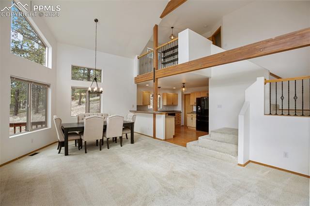 398 Pinewood Road Florissant, CO 80816 - Photo 9 of 43 Carpeted dining room with high vaulted ceiling and a chandelier