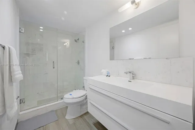 a bathroom with a bathtub shower sink mirror and toilet