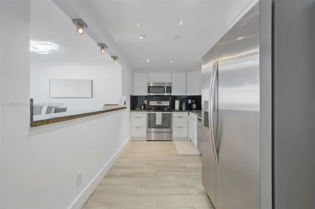 a large kitchen with cabinets and stainless steel appliances
