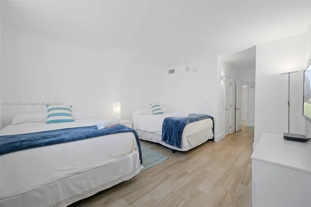 a spacious bedroom with bed and a lamp with wooden floor