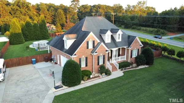 a view of house with a yard and sitting area