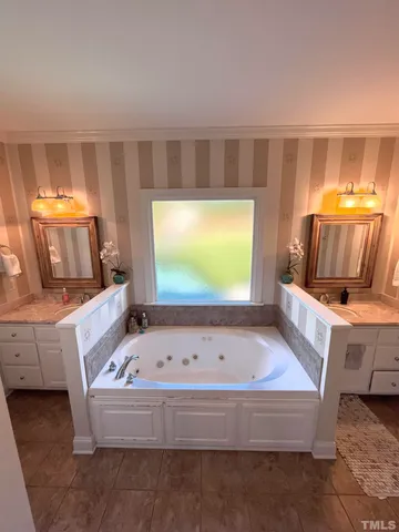 a bathroom with a bathtub and a double vanity sink