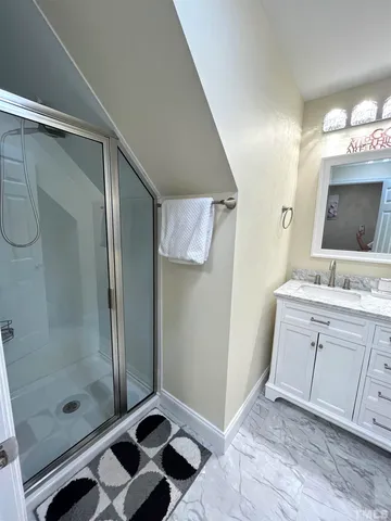 a bathroom with a shower sink and mirror