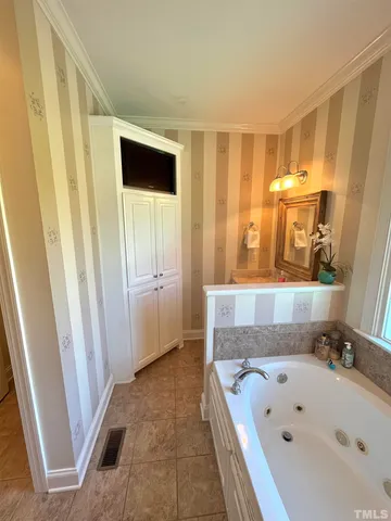 a bathroom with a tub a sink and a large mirror