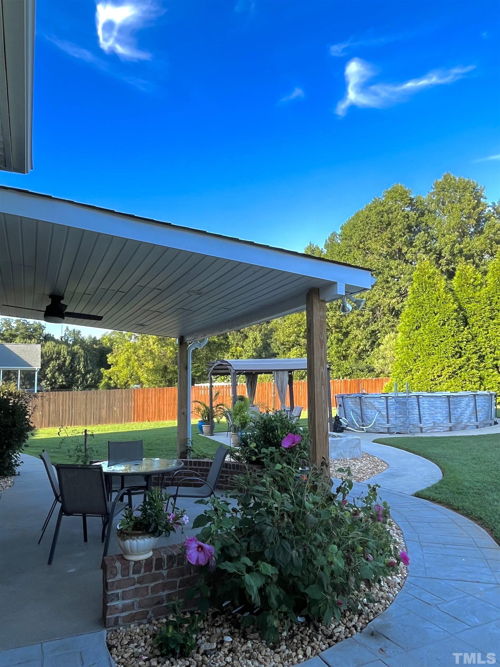 3098 Creek Point Road Haw River, NC 27258 - Photo 4 of 21 a view of a patio with table and chairs under an umbrella with a small yard