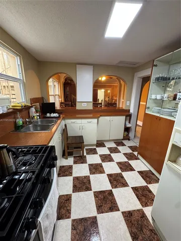 a kitchen with a checkered floor and white cabinets