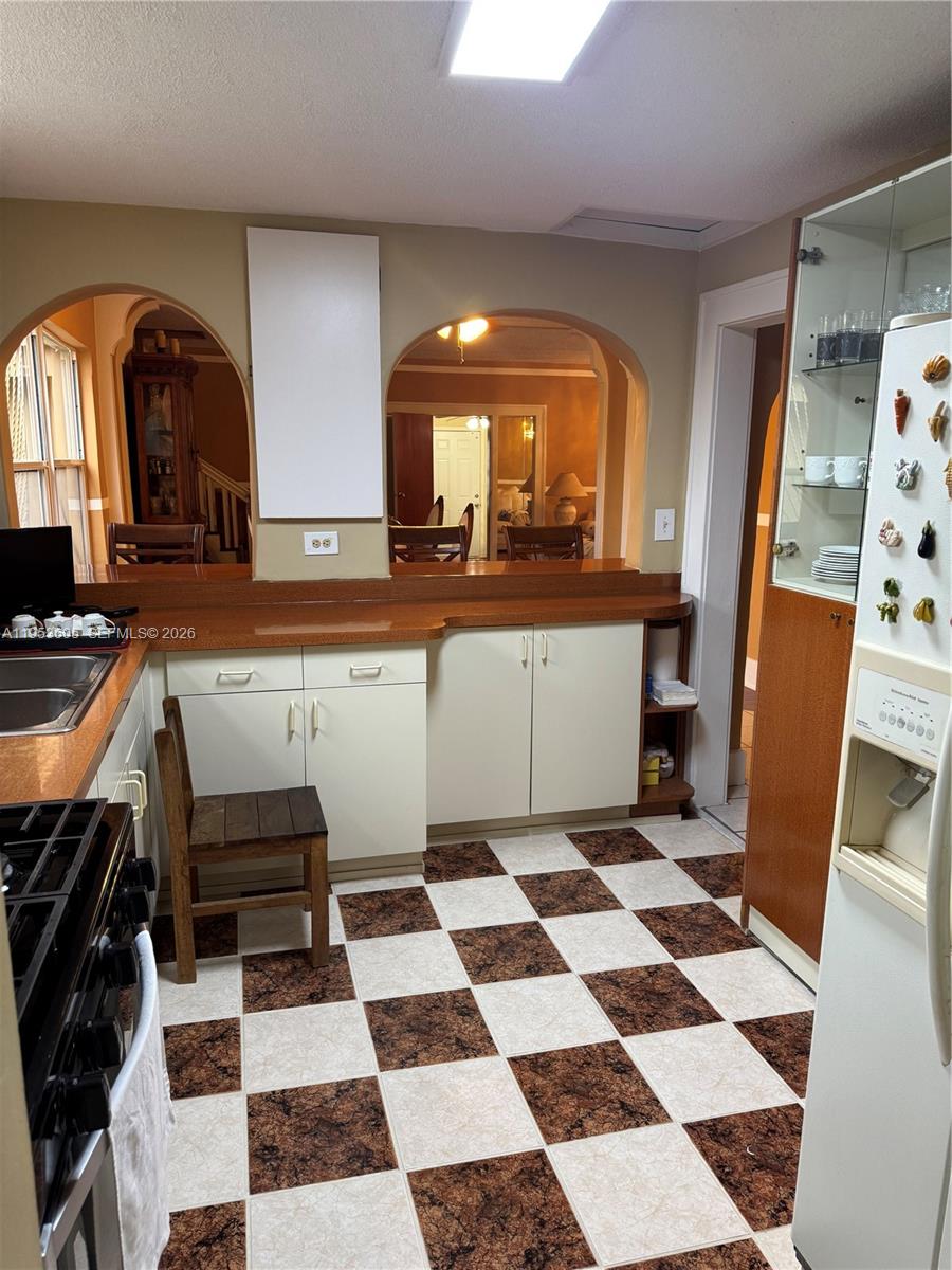 322 Southwest 31st Court Miami, FL 33135 - Photo 10 of 21 a kitchen with a checkered floor and white cabinets