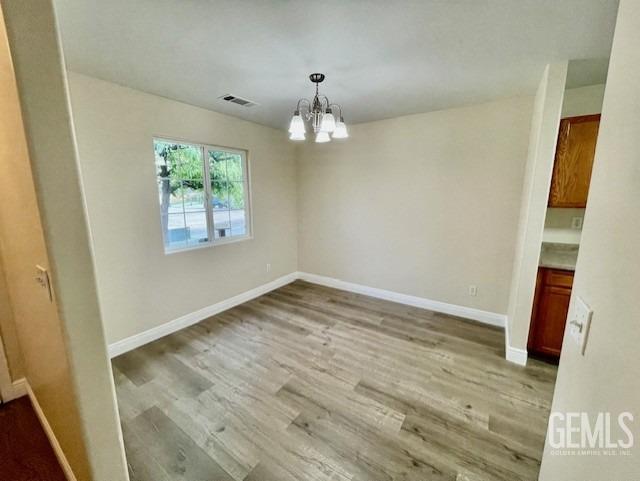 Undisclosed Address Bakersfield, CA 93313 - Photo 5 of 11 an empty room with wooden floor and windows