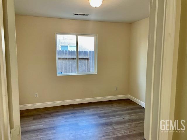 Undisclosed Address Bakersfield, CA 93313 - Photo 6 of 11 an empty room with wooden floor and windows