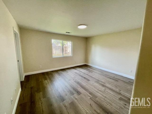 Undisclosed Address Bakersfield, CA 93313 - Photo 8 of 11 an empty room with wooden floor and windows