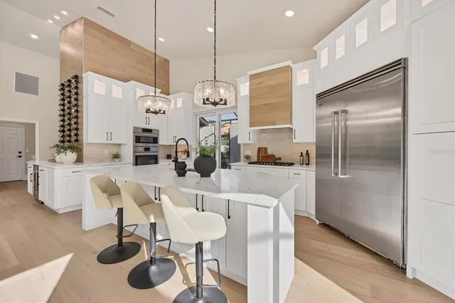a large white bathroom with a double vanity sink a mirror and a bathtub