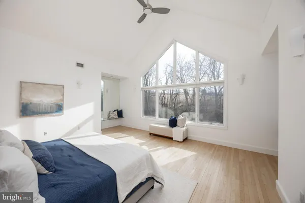 a bedroom with a bed and large window