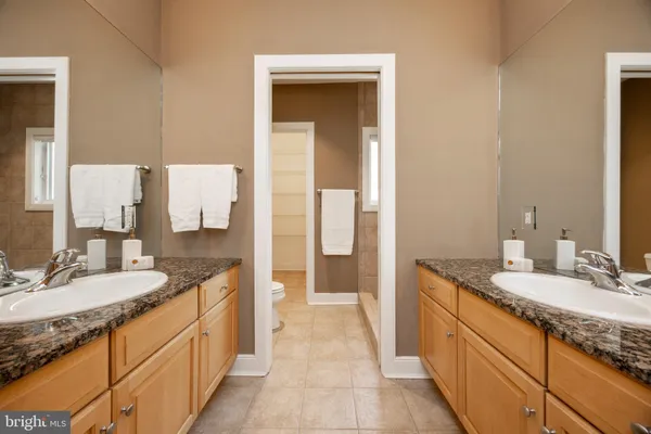 a spacious bathroom with a granite countertop sink and a mirror