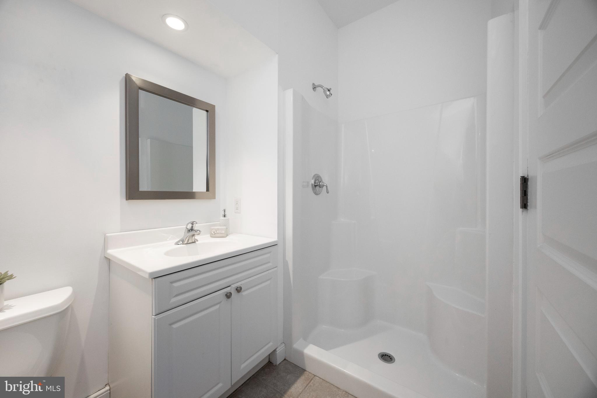 115 Bullock Road Chadds Ford, PA 19317 - Photo 38 of 50 a bathroom with a toilet a sink a mirror and shower