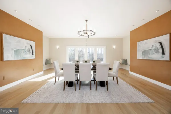 a dining room with wooden floor and a chandelier