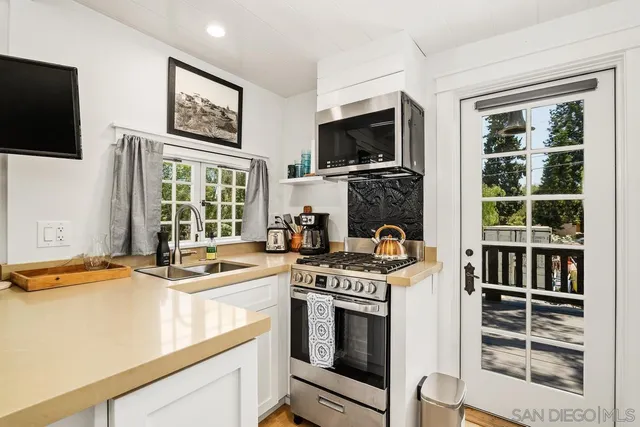 a kitchen with stainless steel appliances a stove microwave and a sink
