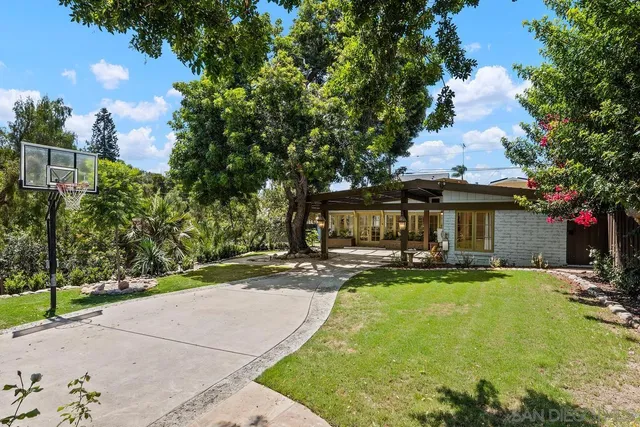 a view of a patio with table and chairs under an umbrella