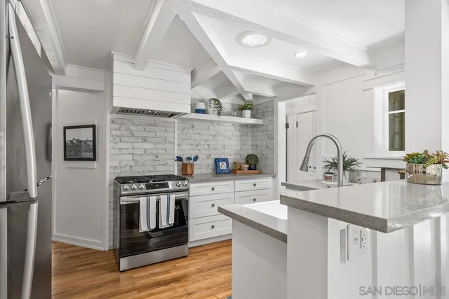 a kitchen with kitchen island stainless steel appliances a sink and a stove
