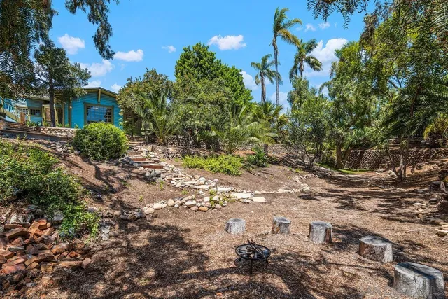 a balcony with table and chairs and potted plants