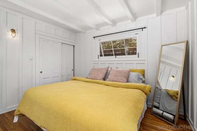 a bed sitting in a spacious bedroom next to a window