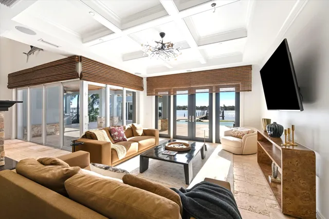 a living room with furniture a flat screen tv and a large window