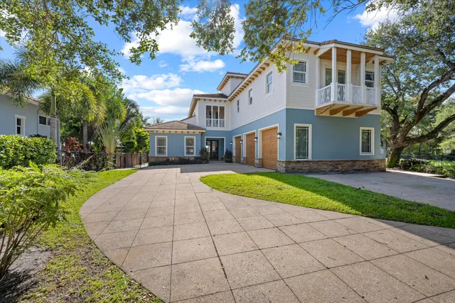 a view of a white house with a yard and large trees