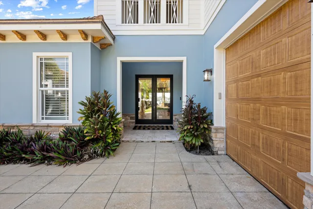 a view of a entryway door of the house with potted plants