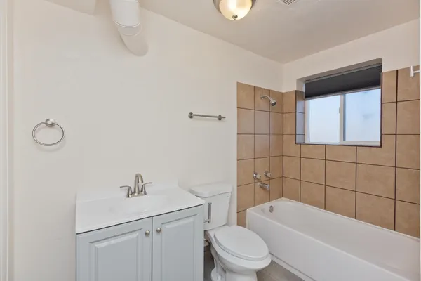 a bathroom with a toilet a sink a mirror a bathtub and vanity