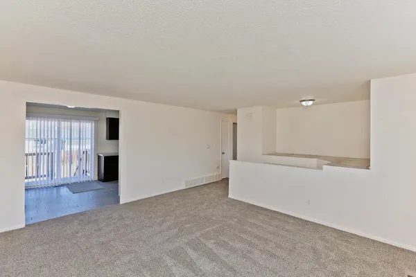 a view of an empty room with wooden floor and windows