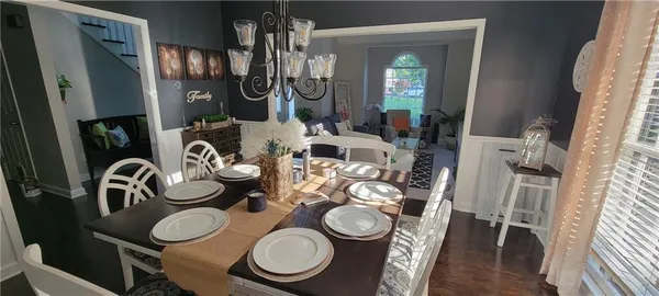 a dining room with furniture a chandelier and wooden floor