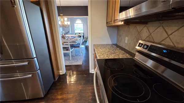 a kitchen with wooden floors and stainless steel appliances