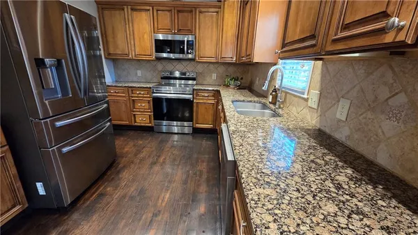a view of a kitchen with wooden floor and staircase