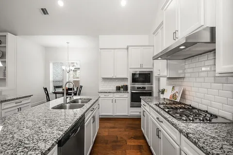 a living room with granite countertop kitchen island furniture and a chandelier