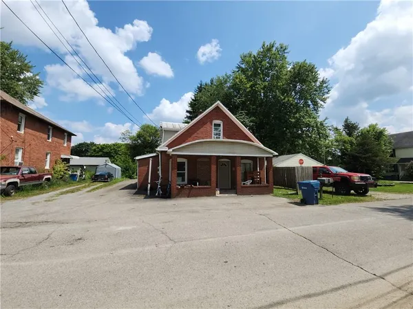 a view of a house with large space and a car parked beside it