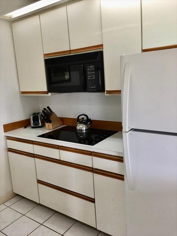 95-789 Ninole Loop Road, Unit 42 Naalehu, HI 96772 - Photo 9 of 17 a kitchen with stainless steel appliances a refrigerator and cabinets